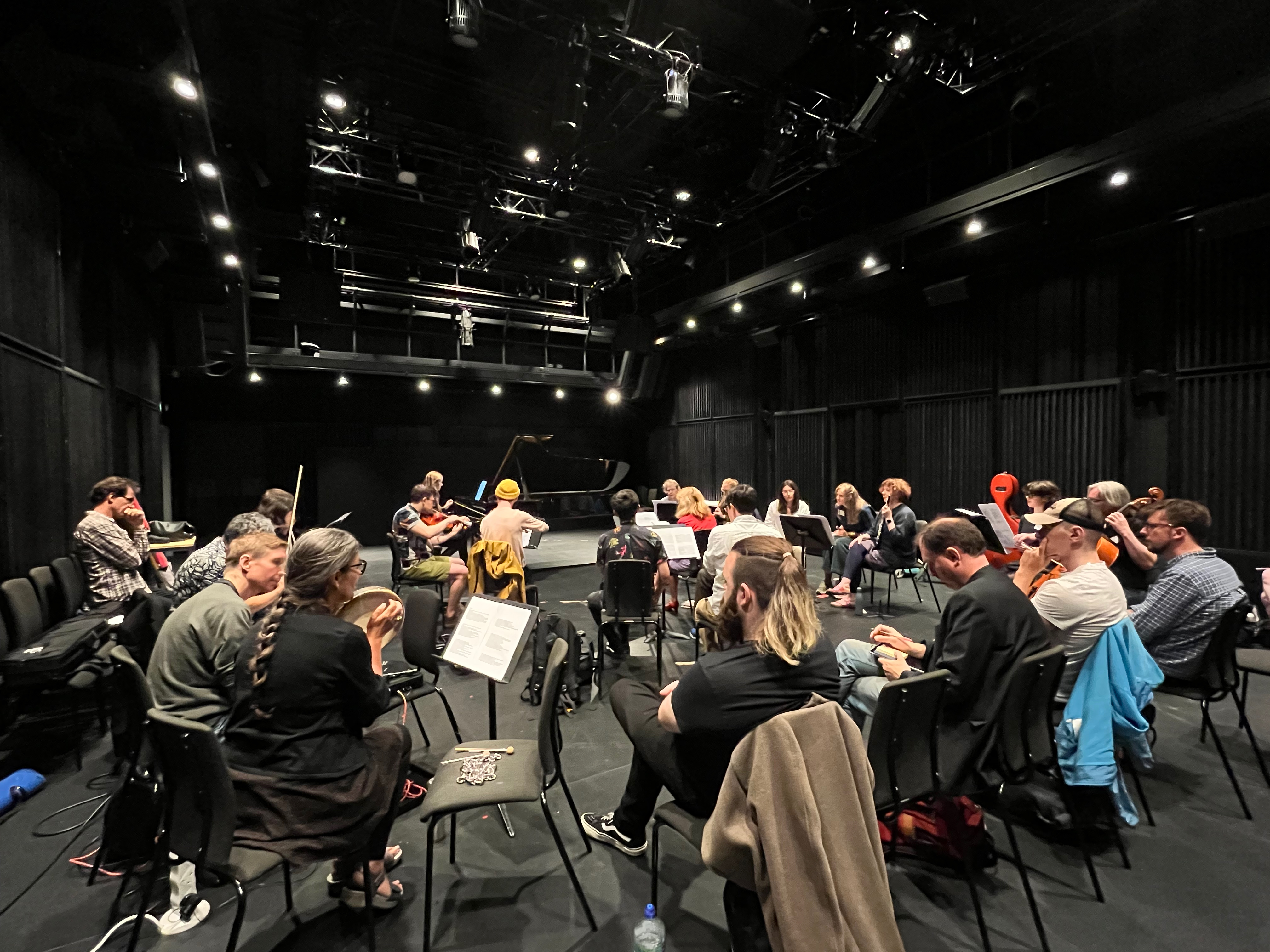 A room full of people with instruments working on an open score